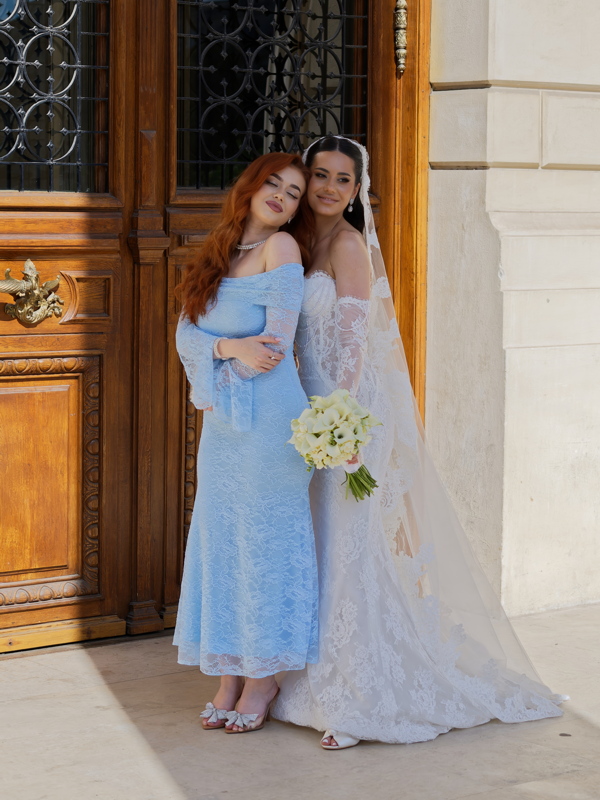 22 - A bride in a Galia Lahav wedding dress posing with a woman dressed in a custom icy-blue Yael gown